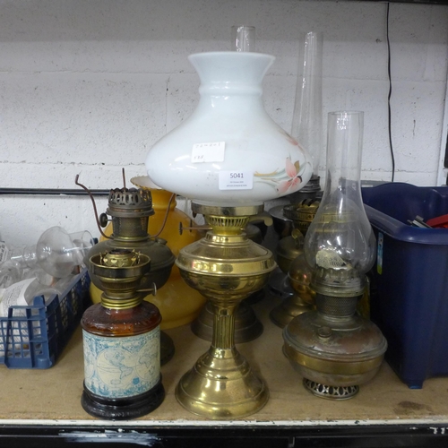 5041 - A collection of nine vintage pressure lamps and a quantity of assorted lamp glasses