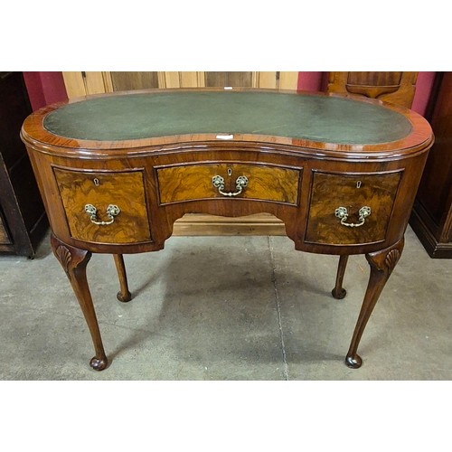 118 - A Queen Anne style walnut and green leather topped kidney shaped desk