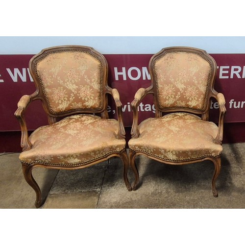 129 - A pair of early 20th Century French Louis XV style carved beech and fabric upholstered fauteuil chai... 