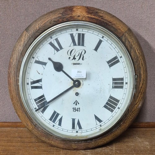 351 - An oak circular wall clock, bearing military inscription to dial