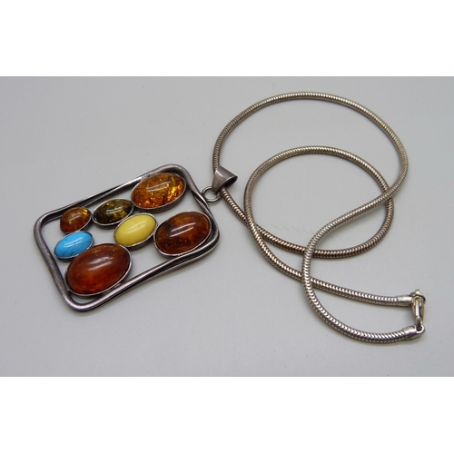 1018 - A silver and Baltic amber pendant on an unmarked metal chain, pendant 6.5 x 3.8cm and 17g