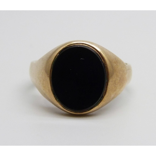 1049 - A 9ct gold and onyx signet ring, 6.8g, V