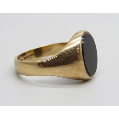 1049 - A 9ct gold and onyx signet ring, 6.8g, V