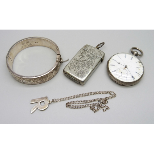 1050 - A silver bangle, 26g, a white metal pocket watch, a plated vesta case, and a silver 'R' pendant on a... 