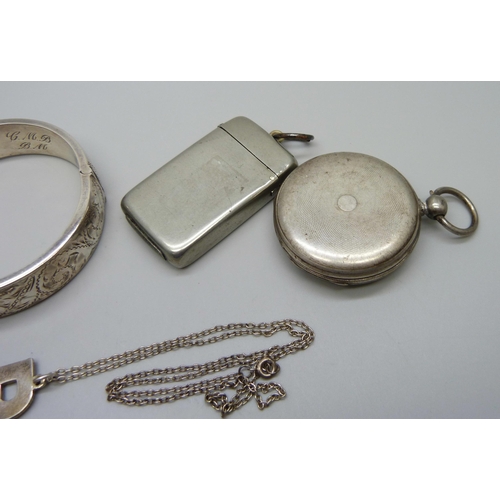 1050 - A silver bangle, 26g, a white metal pocket watch, a plated vesta case, and a silver 'R' pendant on a... 