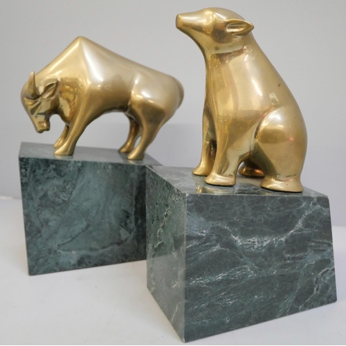 635 - A pair of brass Bull and Bear Wall Street bookends on green marble plinths, tallest 18.5cm