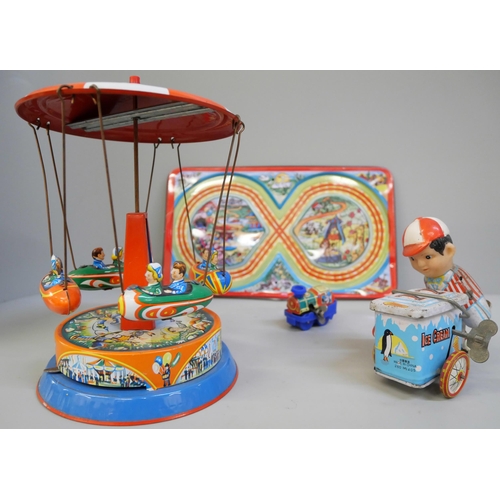 636 - A tin plate carousel, ice-cream vendor and clockwork train with figure of eight track