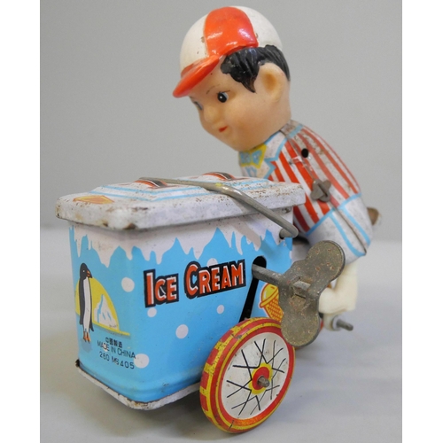 636 - A tin plate carousel, ice-cream vendor and clockwork train with figure of eight track