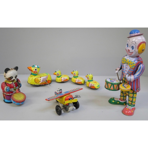 641 - Tin plate toys; clockwork clown, plane, drumming Panda and clockwork ducks