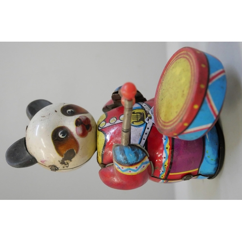 641 - Tin plate toys; clockwork clown, plane, drumming Panda and clockwork ducks