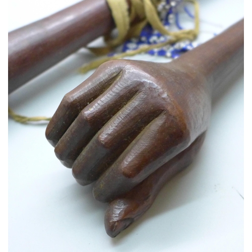 815 - An African tribal club and a carved club or walking cane top in the form a clenched hand