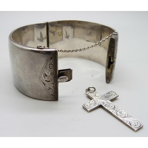 829 - An engraved silver bangle and a silver cross, 3.5cm bangle width, 72g total