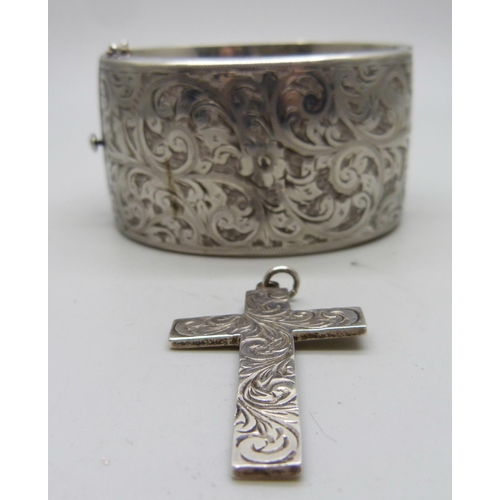 829 - An engraved silver bangle and a silver cross, 3.5cm bangle width, 72g total