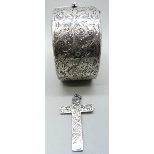 829 - An engraved silver bangle and a silver cross, 3.5cm bangle width, 72g total