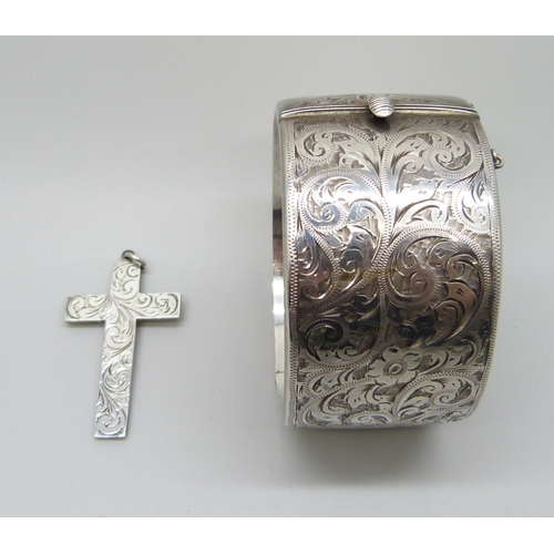 829 - An engraved silver bangle and a silver cross, 3.5cm bangle width, 72g total