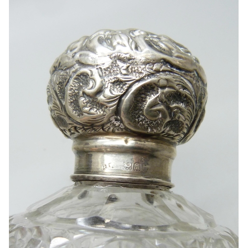 832 - Three cut glass silver topped early 20th Century scent bottles, two lacking stoppers and one without... 