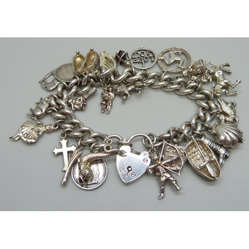 953 - A silver charm bracelet with a collection of silver, white metal and plated charms including a silve... 