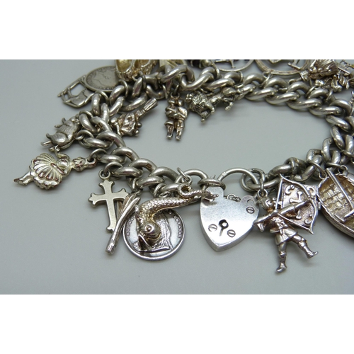 953 - A silver charm bracelet with a collection of silver, white metal and plated charms including a silve... 