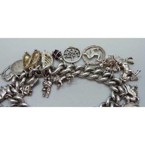 953 - A silver charm bracelet with a collection of silver, white metal and plated charms including a silve... 