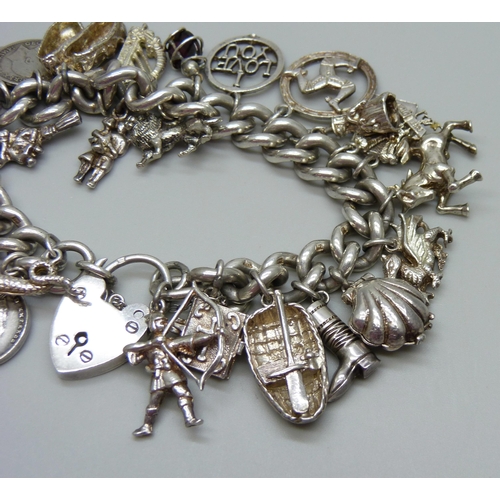 953 - A silver charm bracelet with a collection of silver, white metal and plated charms including a silve... 