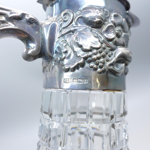 962 - A silver topped claret jug with embossed design, Sheffield 1985, 30cm