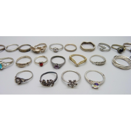 981 - Twenty two silver rings, 48g, together with seven white metal and plated rings