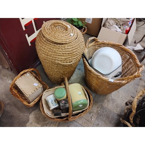 278 - Assorted wicker baskets, tins, an enamelled bread bin, etc.