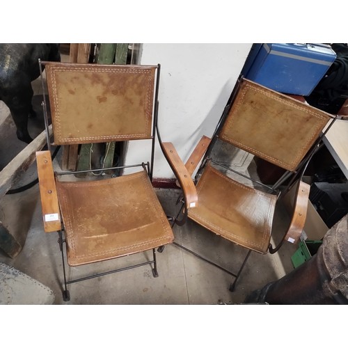 293 - A pair of cast iron and leather folding chairs