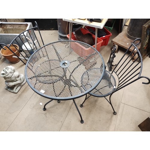 298 - A cast metal and glass topped circular garden table and two chairs