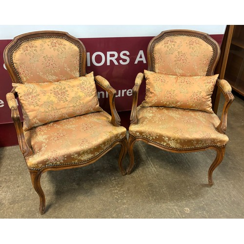 129 - A pair of early 20th Century French Louis XV style carved beech and fabric upholstered fauteuil chai... 