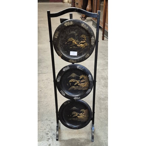 199 - A black Japanned papier mache three tier folding cake stand