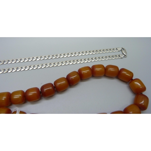 1010 - A butterscotch amber coloured necklace, a silver curb chain, 28g, and a silver bracelet, 16g