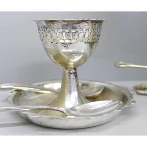 617 - A plated egg warmer by Mappin and Webb, a pair of silver salt spoons, an egg cup and two other spoon... 