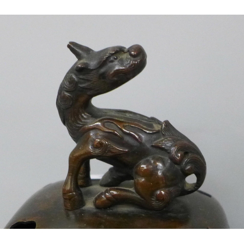 634 - A bronze incense burner with oriental detail and mythical creature to lid