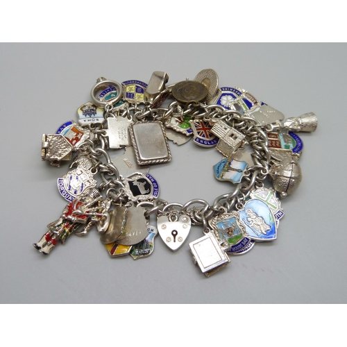 909 - A silver charm bracelet with silver and white metal charms including enamelled examples, 103g