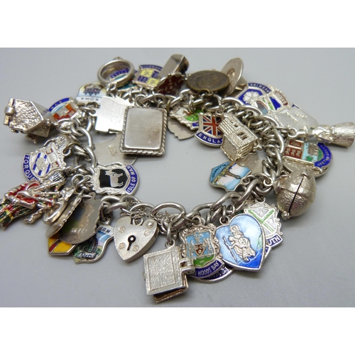 909 - A silver charm bracelet with silver and white metal charms including enamelled examples, 103g