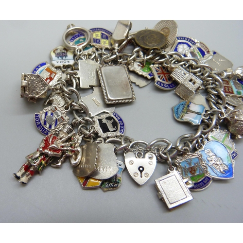 909 - A silver charm bracelet with silver and white metal charms including enamelled examples, 103g