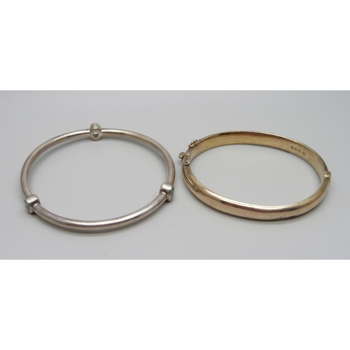 913 - Two silver bangles, one set with topaz, 22g total