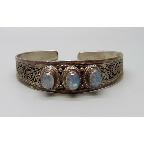 924 - A white metal and moonstone bangle, stamped 925, 25g