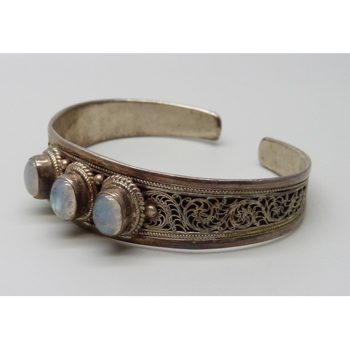 924 - A white metal and moonstone bangle, stamped 925, 25g