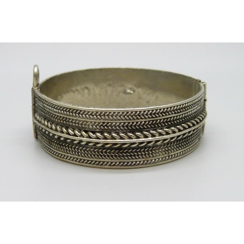 950 - An Eastern metal bangle, 1.9cm wide