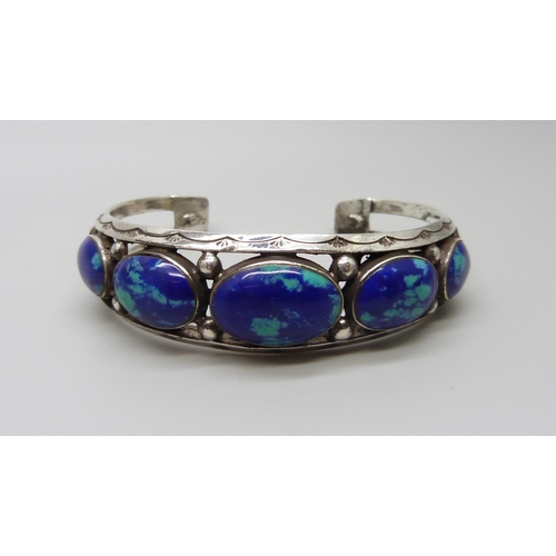 954 - A white metal bangle set with cabochon blue stones, 37g, largest stone 1.9 x 1.3cm