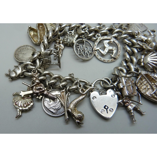 991 - A silver charm bracelet with a collection of silver, white metal and plated charms including a silve... 