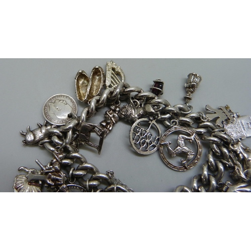 991 - A silver charm bracelet with a collection of silver, white metal and plated charms including a silve... 