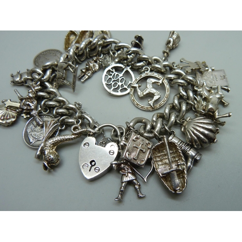 991 - A silver charm bracelet with a collection of silver, white metal and plated charms including a silve... 