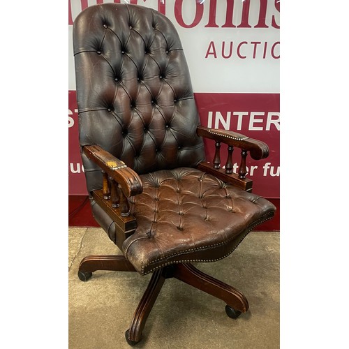 111 - A mahogany chestnut brown leather revolving desk chair