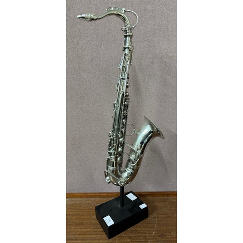 330 - A silvered sculpture of a saxophone on stand