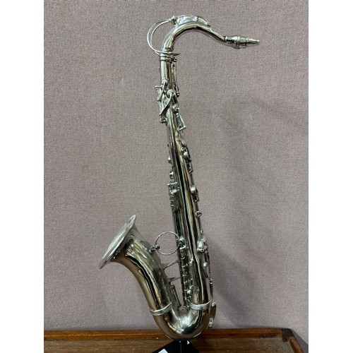 330 - A silvered sculpture of a saxophone on stand