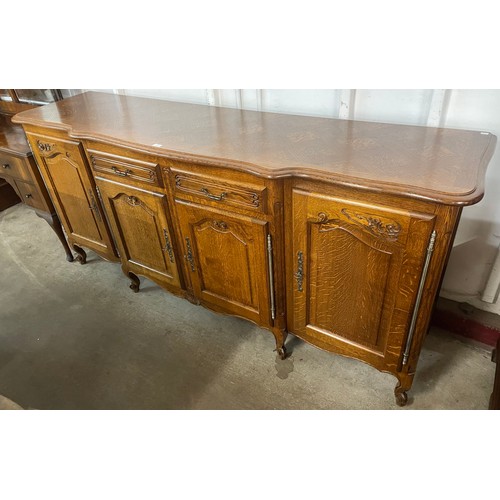 141 - An 18th Century style French Breton carved oak breakfront sideboard