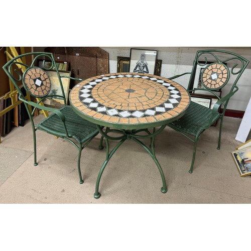 320 - A cast metal and mosaic tile topped garden table and two chairs